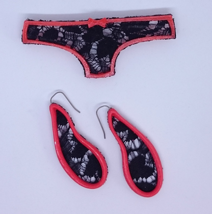 Sustainable Me! Red PLA filament printed onto black lace, made into a brooch in the shape of panties.  (March/April 2020). The earrings, also red PLA filament printed onto black lace, have titanium earwires added when the printing was paused.
